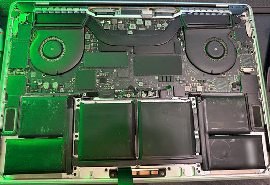 MacBook Pro opened with fans and heat pipe exposed for thermal paste replacement and cleaning at Franchitti's Fix near City Heights